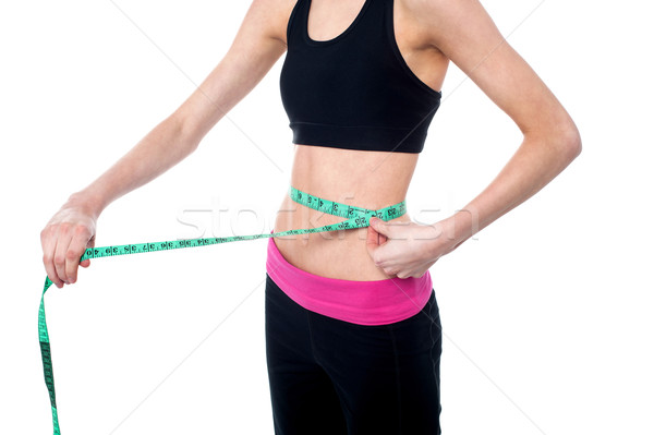 Woman measuring her waist Stock photo © stockyimages