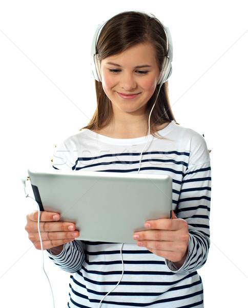 Pretty young girl enjoys listening music Stock photo © stockyimages