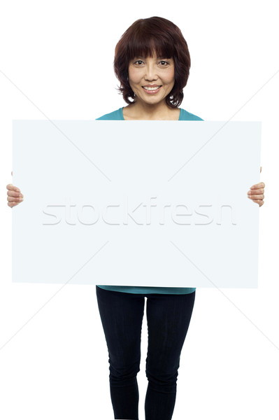 Woman holding billboard, your ad here Stock photo © stockyimages