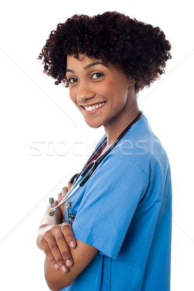 Sorridente feminino médico em pé dobrado brasão Foto stock © stockyimages