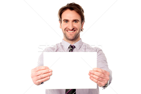 Male executive holding out blank ad board Stock photo © stockyimages