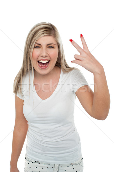 Gorgeous blonde girl gesturing victory sign Stock photo © stockyimages