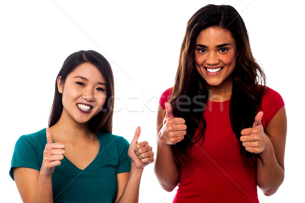 Two girls cheering up with thumbs up Stock photo © stockyimages