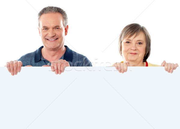 Old age couple holding blank banner ad Stock photo © stockyimages