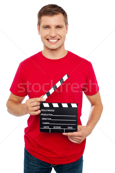 Smiling young guy holding clapperboard Stock photo © stockyimages