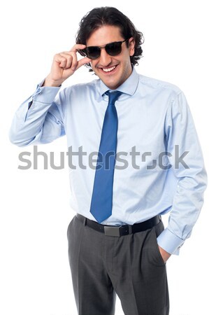Young business achiever holding shades in style Stock photo © stockyimages