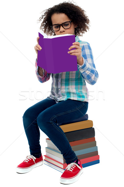 Young kid concentrating while reading a book Stock photo © stockyimages