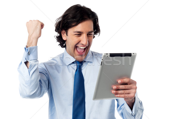 Excited businessman holding touch pad Stock photo © stockyimages