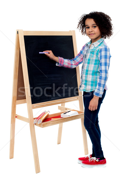 Happy schoolchild writing on blackboard Stock photo © stockyimages