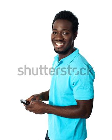 Adolescente mensajería teléfono sonriendo cámara modelo Foto stock © stockyimages