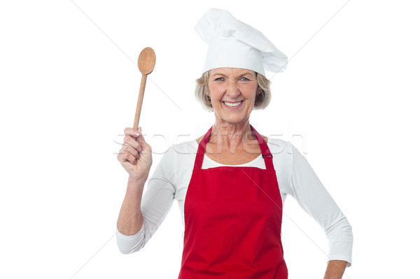 Happy aged chef holding wooden spoon Stock photo © stockyimages