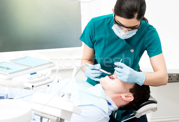 Dentist cleaning patient teeth  Stock photo © stockyimages