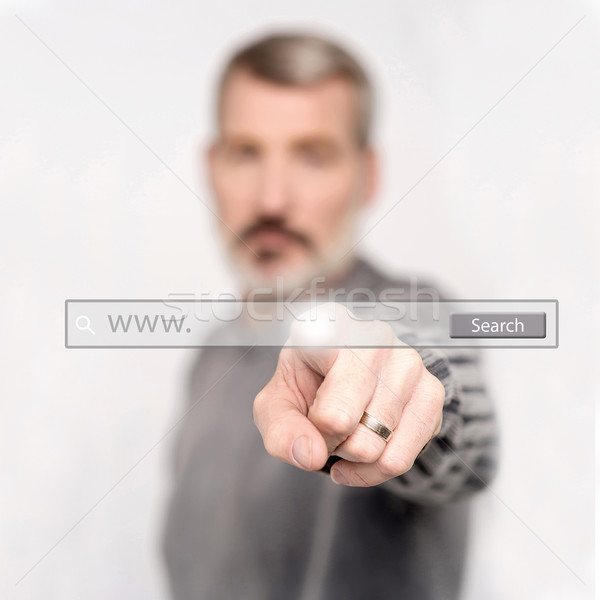 Man pointing at search bar on virtual screen Stock photo © stockyimages