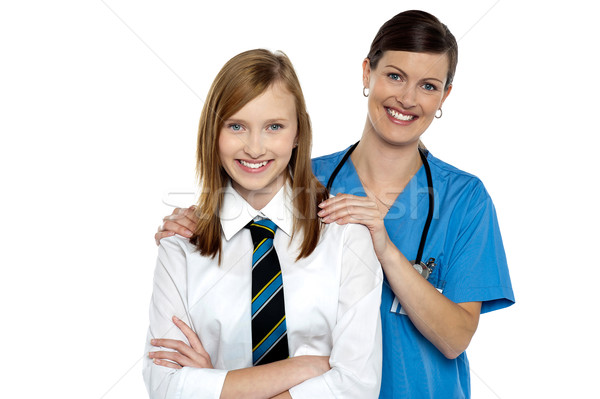 Graceful doctor posing with her teenage patient Stock photo © stockyimages