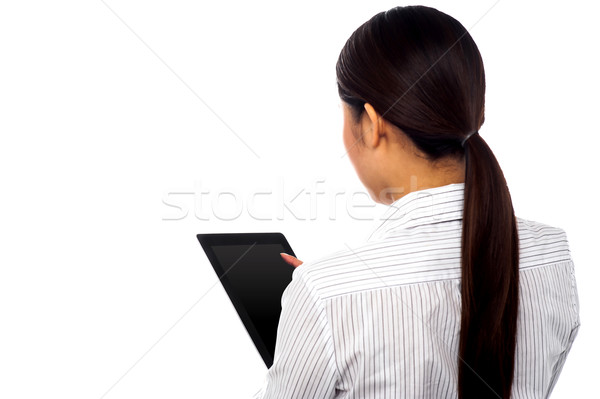 Back pose of a woman operating touch pad device Stock photo © stockyimages