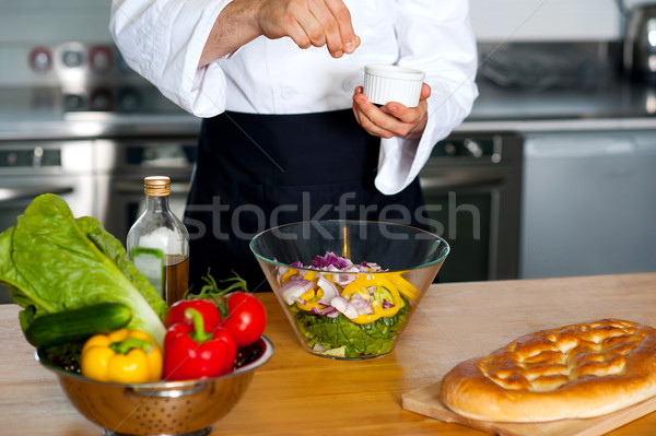 Chef sprinkling salt on vegetables Stock photo © stockyimages