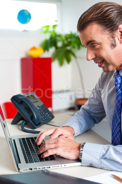 Biznesmen wpisując sprawozdanie laptop obraz biuro Zdjęcia stock © stockyimages