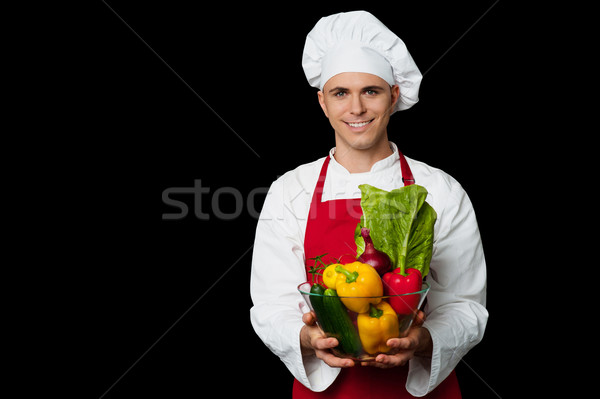 Handsome chef holding vegetables bowl Stock photo © stockyimages