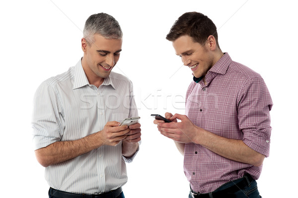 Young casual men using their smart phone Stock photo © stockyimages