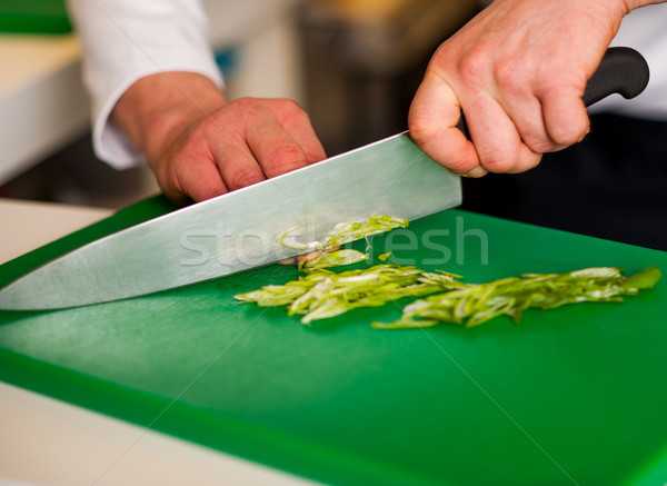Chef chopping leek and doing preparations Stock photo © stockyimages