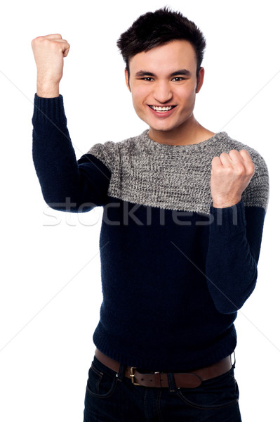 Excited young guy with clenched fists Stock photo © stockyimages