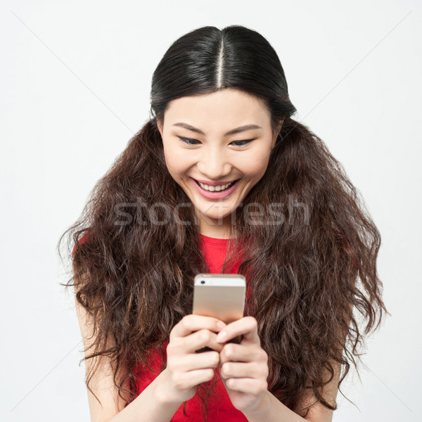 Pretty amused girl reading funny sms Stock photo © stockyimages