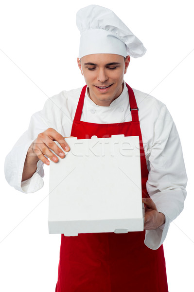 Stock photo: Young male chef holding pizza box