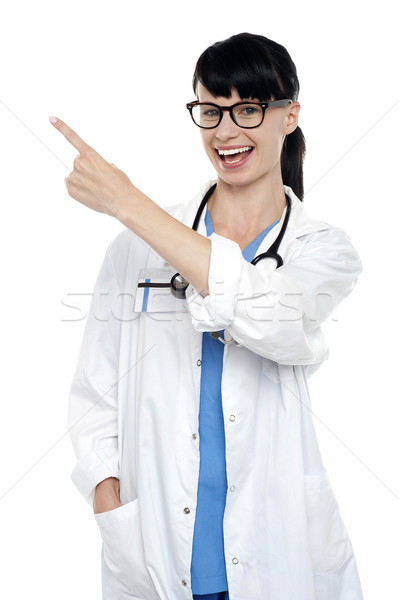 Wesoły lekarz wskazując z dala kopia przestrzeń Zdjęcia stock © stockyimages