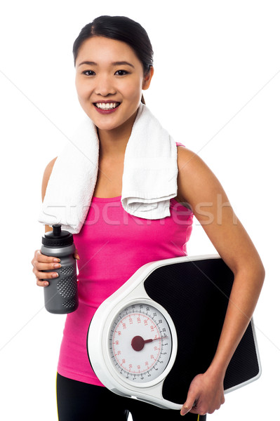 Fit girl holding weight scale and sipper bottle Stock photo © stockyimages