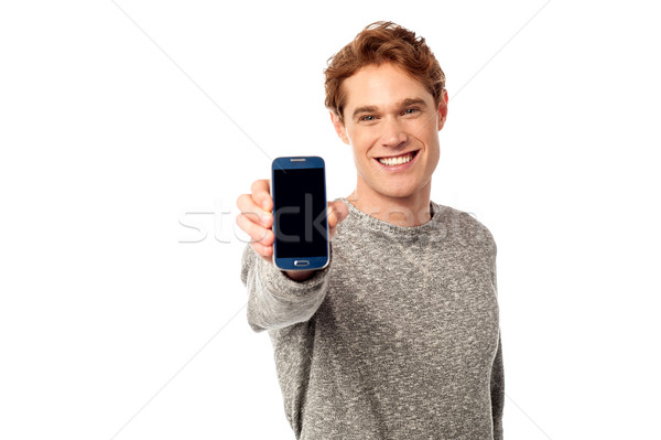 Young man displaying brand new cellphone Stock photo © stockyimages