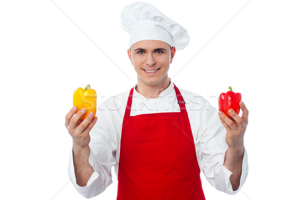 Chef in uniform showing capsicums  Stock photo © stockyimages