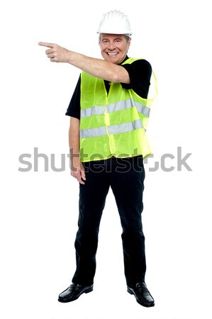 Cheerful estate engineer indicating sideways Stock photo © stockyimages