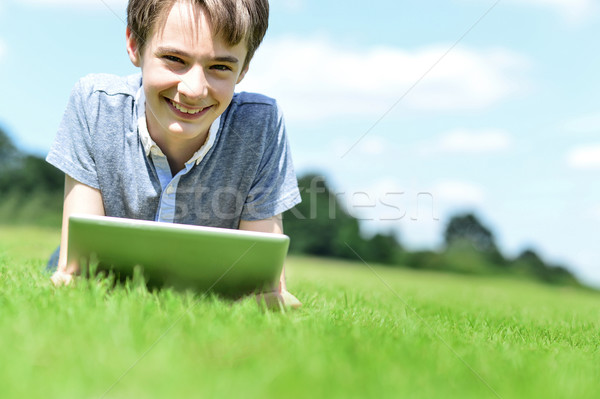 Handsome young boy with tablet device, outdoors. Stock photo © stockyimages
