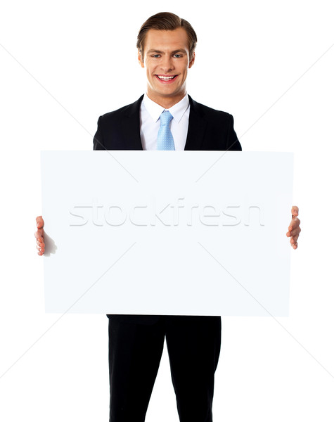 Stock photo: Young businessman holding white blank billboard
