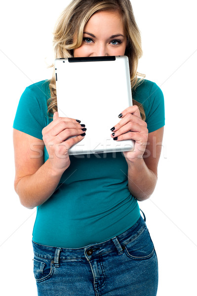 Shy pretty model hiding face with tablet pc Stock photo © stockyimages