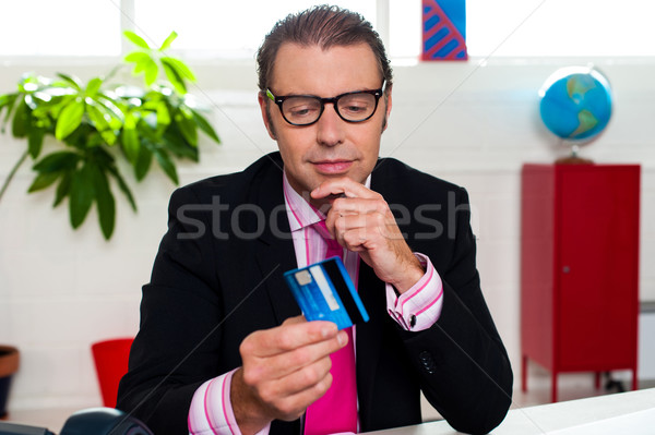 Corporate man staring at his credit card Stock photo © stockyimages
