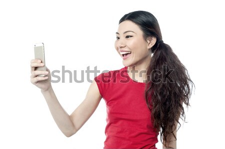 Amused girl clicking a selfie Stock photo © stockyimages