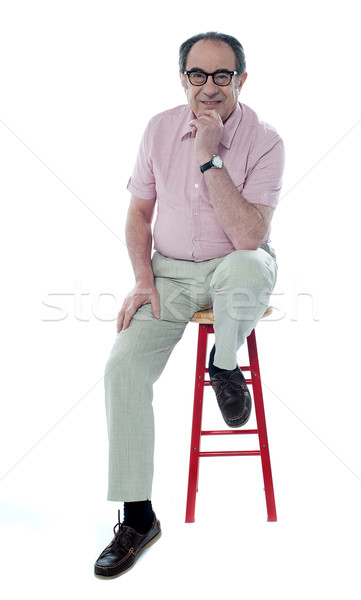Confident senior man resting on stool Stock photo © stockyimages