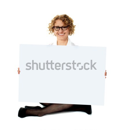 Female employee holding white blank banner ad Stock photo © stockyimages