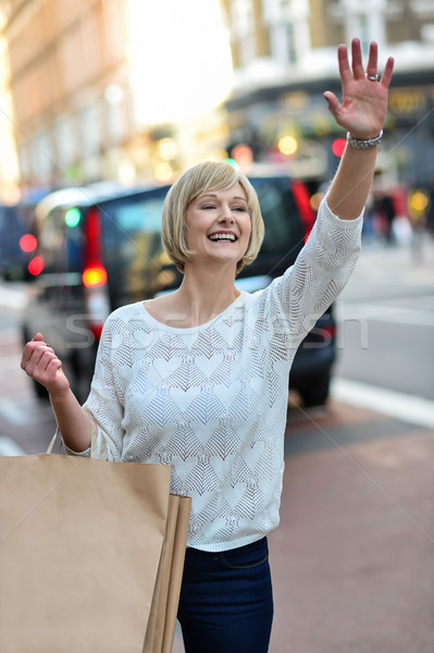Casual woman hailing a taxi cab Stock photo © stockyimages