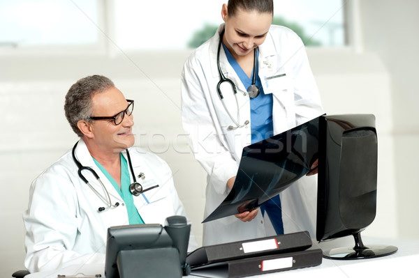 Team of two doctors reviewing x-ray report Stock photo © stockyimages
