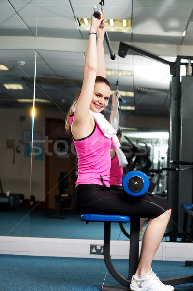 Woman toning her upper and core muscles in multi gym Stock photo © stockyimages