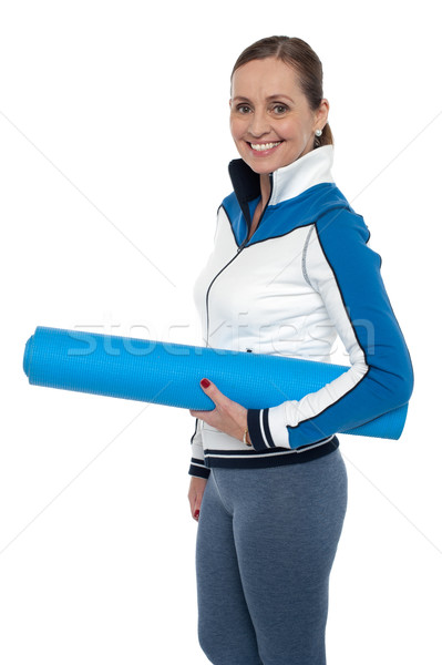 Woman carrying blue yoga mat Stock photo © stockyimages