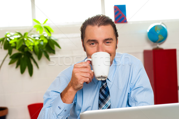 Smiling male manager enjoying hot coffee Stock photo © stockyimages