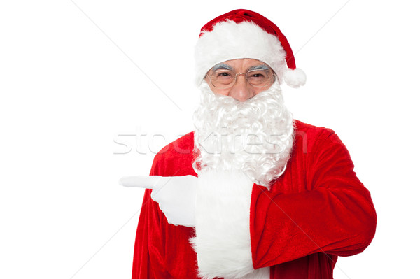 Santa claus pointing away over white Stock photo © stockyimages