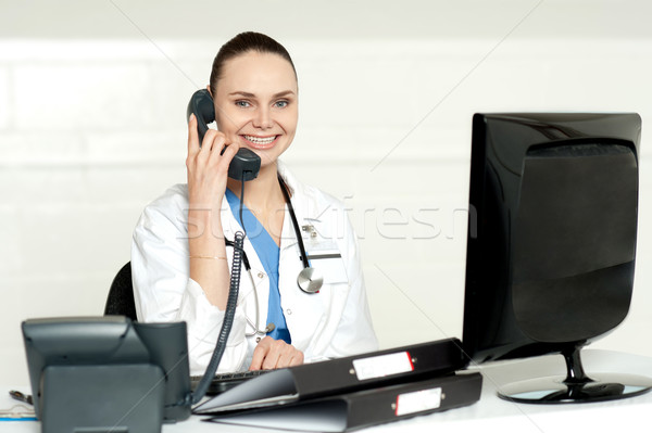 Beautiful nurse talking on phone with patient Stock photo © stockyimages