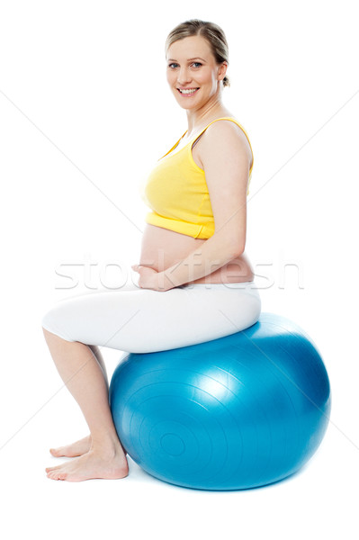 Femeie gravida şedinţei gimnastica bilă izolat alb Imagine de stoc © stockyimages