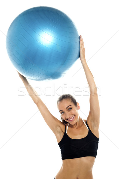 woman holding big blue pilates ball above her head Stock photo © stockyimages