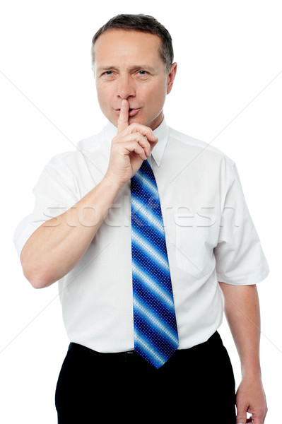 Business man with finger on lips asking for silence Stock photo © stockyimages