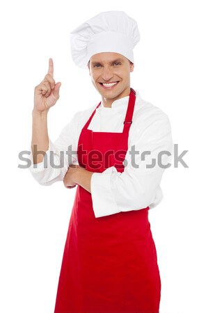 Stock photo: Aged woman chef pointing at copy space area